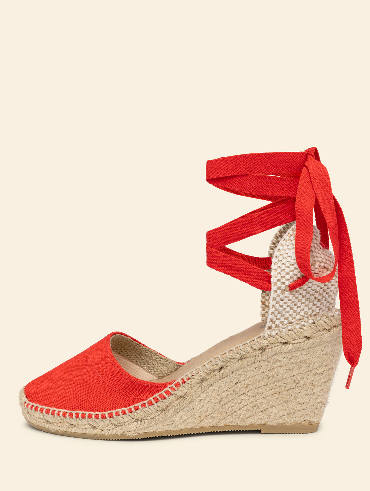 Natural jute wedge espadrille about 9 centimeters high, rounded and low-cut closed toe, with ribbons to tie at the ankle, padded insole for greater comfort.